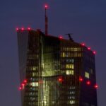 FILE – Red lights shine on top of the European Central Bank in Frankfurt, Germany, Sept. 7, 2021. The European Central Bank is behind the U.S. Federal Reserve and other central banks around the world in combating surging inflation. It’s looking to catch up as it raises interest rates for the first time in 11 years Thursday July 21, 2022, but it also faces a more serious threat of recession than other places amid an energy crisis provoked by Russia’s war in Ukraine. (AP Photo/Michael Probst, File)