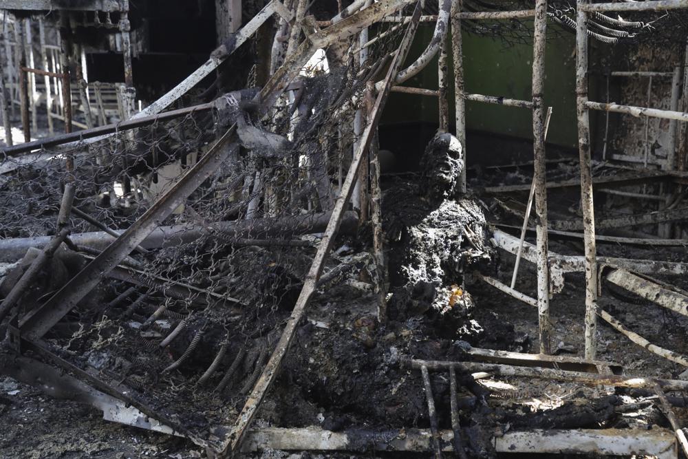 EDS NOTE: GRAPHIC CONTENT – A burned out body of Ukrainian military prisoner is seen in destroyed barrack at a prison in Olenivka, in an area controlled by Russian-backed separatist forces, eastern Ukraine, Friday, July 29, 2022. Russia and Ukraine accused each other Friday of shelling the prison in Olenivka in a separatist region of eastern Ukraine, an attack that reportedly killed dozens of Ukrainian military prisoners who were captured after the fall of a southern port city of Mariupol in May. (AP Photo)