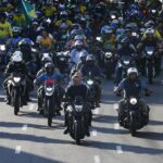 FILE – Brazil’s President Jair Bolsonaro, center, leads a motorcycle rally in Manaus, Brazil, June 18, 2022. With the election just three months off, some polls show only one in five women will vote for the tough-talking, pro-gun, motorcycle-riding former Army captain. (AP Photo/Edmar Barros, File)