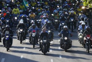 FILE – Brazil’s President Jair Bolsonaro, center, leads a motorcycle rally in Manaus, Brazil, June 18, 2022. With the election just three months off, some polls show only one in five women will vote for the tough-talking, pro-gun, motorcycle-riding former Army captain. (AP Photo/Edmar Barros, File)