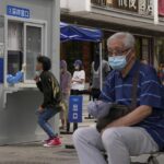 Residents line up to get a throat swab at a testing site as they are required for a negative COVID test in the last 72 hours before entering some buildings and using public transportation in Beijing, Tuesday, July 19, 2022. Authorities in southern China apologized for breaking into the homes of people quarantined for being suspected of contracting COVID-19 in the latest example of heavy-handed measures that have sparked a rare public backlash. (AP Photo/Andy Wong)