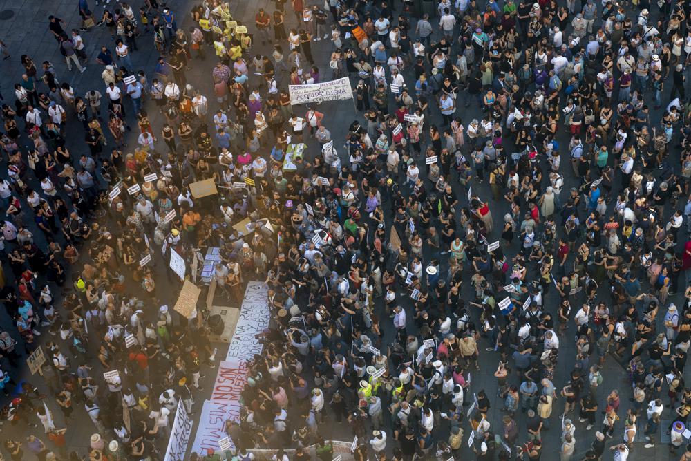 People gather during a protest over the deaths of at least 23 people at the border between the Spanish enclave of Melilla and Morocco grow at Callao square in Madrid, Spain, Friday, July 1, 2022. Thousands of people across cities in Spain have taken to the streets Friday to protest the deaths of at least 23 people at the border between the Spanish enclave of Melilla and Morocco, amid growing calls for an investigation. (AP Photo/Manu Fernandez)