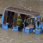 A rickshaw driver and a volunteer push a rickshaw stuck in a flooded road after a heavy rainfall in Karachi, Pakistan, Monday, July 11, 2022. The death toll from rain-related incidents over the past month has risen to over 140 as monsoon rains continue to lash Pakistan, triggering flash floods in some parts of the country, officials said. (AP Photo/Fareed Khan)