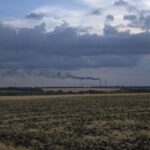 Grain fields backdropped by a power plant in Donetsk region, eastern Ukraine, Friday, July 22, 2022. (AP Photo/Nariman El-Mofty)