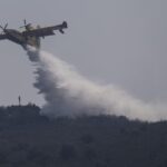 A firefighting plane drops water during fire extinguish works near Tabara, north-west Spain, Wednesday, July 20, 2022. (AP Photo/Bernat Armangue)