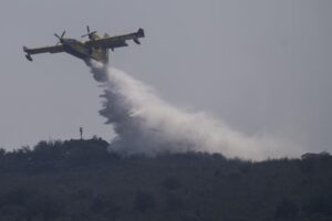 A firefighting plane drops water during fire extinguish works near Tabara, north-west Spain, Wednesday, July 20, 2022. (AP Photo/Bernat Armangue)