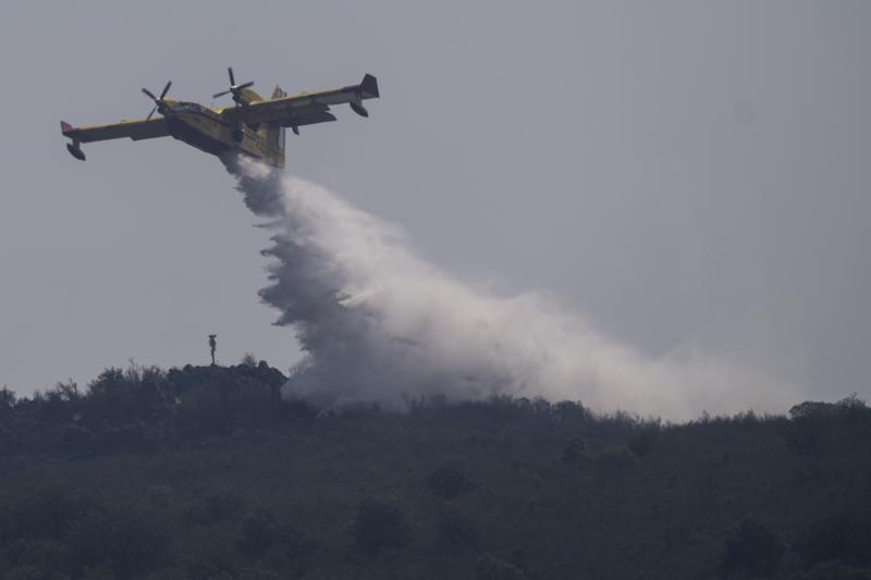 A firefighting plane drops water during fire extinguish works near Tabara, north-west Spain, Wednesday, July 20, 2022. (AP Photo/Bernat Armangue)
