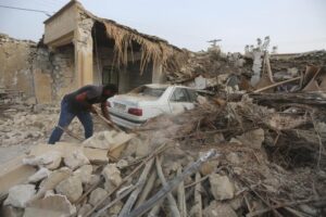 A man cleans up the rubble after an earthquake at Sayeh Khosh village in Hormozgan province, some 620 miles (1,000 kilometers) south of the capital, Tehran, Iran, Saturday, July 2, 2022. (AP Photo/Abdolhossein Rezvani)