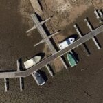 FILE – Pleasure boats tied to a pier rest on dry ground of the water depleted Zezere River due to drought, near Figueiro dos Vinhos in central Portugal, Feb. 17, 2022. Portugal is bracing for a heat wave, with temperatures in some areas forecast to climb as high as 43 degrees Celsius this weekend just as a severe drought grips the country. The Civil Protection Agency, a government body that coordinates official responses to emergencies, is placing crews on high alert Thursday, July 7, 2022 due to the risk of wildfires. (AP Photo/Sergio Azenha, File)