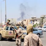 Members of the Libyan armed unit, 444 Brigade, backing the Government of National Unity (GNU) and its Prime Minister Abdulhamid al-Dbeibah, set up a checkpoint as smoke rises in the background in Ain Zara area in Tripoli, Libya, July 22, 2022.