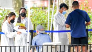 Health care workers with New York City Department of Health and Mental Hygiene help people register for the monkeypox vaccine at one of the city’s vaccination sites, July 26, 2022, in New York.