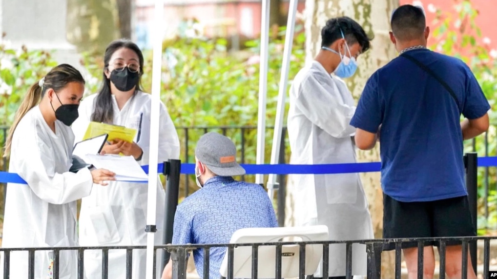 Health care workers with New York City Department of Health and Mental Hygiene help people register for the monkeypox vaccine at one of the city’s vaccination sites, July 26, 2022, in New York.