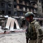 A Ukrainian serviceman passes destroyed buildings in the Ukrainian town of Siversk, Donetsk region, on July 22, 2022, amid the Russian invasion of Ukraine.