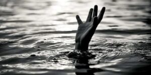 An image of a hand of a drowning child emerging from water