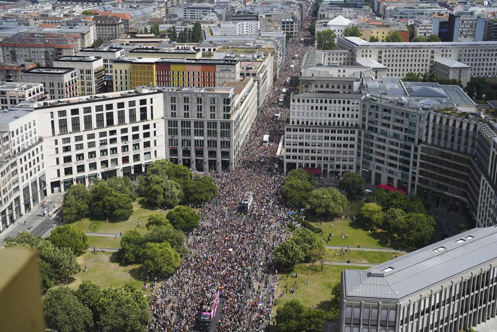 Revelers march down the Leipziger Strasse street on the Leipziger Platz square during the annual pride march in the German capital Berlin, Saturday, July 23, 2022. (AP Photo/Markus Schreiber)