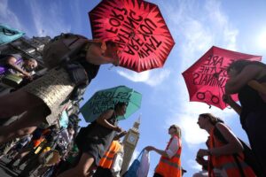 Members of environmental groups including Just Stop Oil, the Peace and Justice Project and Insulate Britain take part in a mass protest, in Parliament Square, London, Saturday, July 23, 2022. (AP Photo/Alessandra Tarantino)