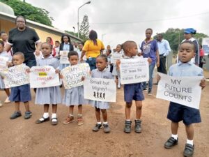 Protesting school children carrying placards in front of OAU