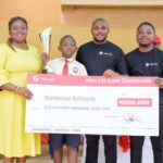 L-R: Proprietress, Gateway Schools, Enugu, Dr Loveline Ndu; Winner, Heirs Life Essay Championship, Ugbomyke Princewill; Communications Manager, Heirs Life Assurance Limited, Timilehin Adebiyi and Head, Retail Sales, Heirs, Olugbenga Osibodu, at the presentation ceremony of Heirs Life Essay Championship Cup at Gateway Schools, Enugu