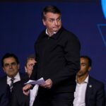 President Jair Bolsonaro gets up to speak during an event with business leaders from the poultry and pork sectors in Sao Paulo, Brazil, Tuesday, Aug. 9, 2022. (AP Photo/Marcelo Chello)