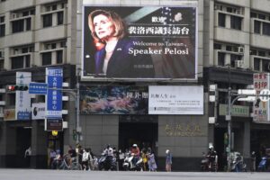 FILE – People walk past a billboard welcoming U.S. House Speaker Nancy Pelosi, in Taipei, Taiwan, Aug 3, 2022. Days after Ayman al-Zawahiri was killed in Kabul, China staged large-scale military exercises and threatened to cut off contacts with the U.S. over House Speaker Nancy Pelosi’s visit to Taiwan. (AP Photo/Chiang Ying-ying, File)