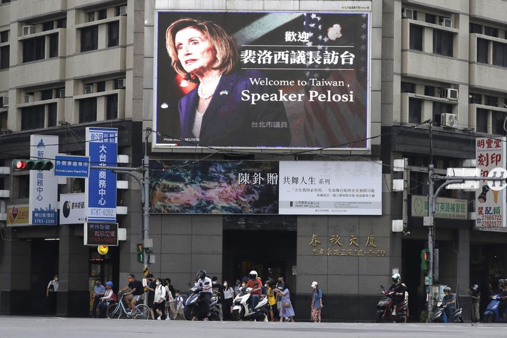 FILE – People walk past a billboard welcoming U.S. House Speaker Nancy Pelosi, in Taipei, Taiwan, Aug 3, 2022. Days after Ayman al-Zawahiri was killed in Kabul, China staged large-scale military exercises and threatened to cut off contacts with the U.S. over House Speaker Nancy Pelosi’s visit to Taiwan. (AP Photo/Chiang Ying-ying, File)