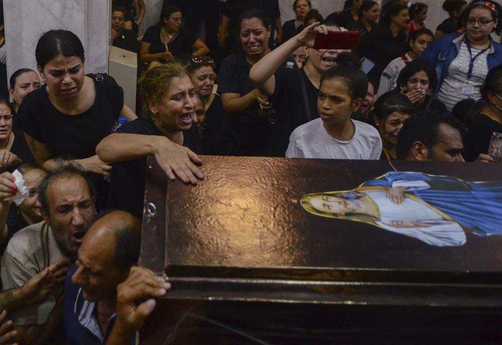 FILE – Mourners attend a service for victims of a fire in a crowded church that killed dozens, at the Blessed Virgin Mary Church in Warraq, greater Cairo, Sunday, Aug. 14, 2022. The fire at the Martyr Abu Sefein Church in the neighborhood of Imbaba, one of Egypt’s most densely populated, left many families devastated, striking a Christian community that is one of the world’s oldest, but is also no stranger to sadness. A minority in Egypt, Coptic Orthodox Christians have faced deadly attacks by Islamist extremists, restrictions on church building and outbursts of sectarian-motivated violence in recent decades. (AP Photo/Tarek Wajeh, File)