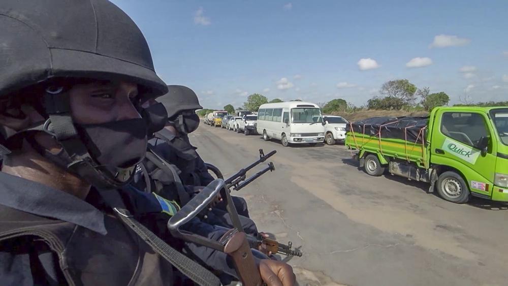 In this image made from video, Rwandan police patrol a road in Palma, Cabo Delgado province, Mozambique, Sunday Aug. 15, 2021. A new offensive by Mozambique’s Islamic extremist rebels in Cabo Delgado has increased the number of displaced by 80,000 and undermines the government’s claims of containing the insurgency. (AP Photo/Marc Hoogsteyns)