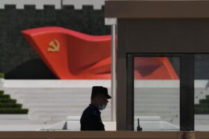 FILE – A security guard stands near a sculpture of the Chinese Communist Party flag at the Museum of the Communist Party of China on May 26, 2022, in Beijing. China said it was conducting military exercises Saturday, July 30, off its coast opposite Taiwan after warning Speaker Nancy Pelosi of the U.S. House of Representatives to scrap possible plans to visit the island democracy, which Beijing claims as part of its territory. (AP Photo/Ng Han Guan, File)