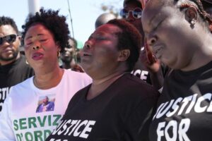 Charity Oriakhi, center, widow of Nigerian street vendor Alika Ogochukwu, attends a demonstration to demand justice for her husband in Civitanova Marche, Italy, Saturday, Aug. 6, 2022. The brutal killing of Ogochukwu in broad daylight has sparked a debate in this well-to-do Adriatic beach community over whether the attack by an Italian man with a court-documented history of mental illness was racially motivated. (AP Photo/Antonio Calanni)