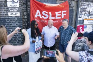 Aslef General Secretary Mick Whelan,centre, speaks to the media alongside Labour MPs Dawn Butler and Barry Gardiner at a picket line at Willesden Junction station as members of the drivers union at nine train operators walk out for 24 hours over pay, in London, Saturday, Aug. 13, 2022. Thousands of U.K. train drivers walked off the job Saturday in a strike over jobs, pay and conditions, scuppering services across much of the country. It’s the latest in a spreading series of strikes by British workers seeking substantial raises to offset soaring prices for food and fuel. (Dominic Lipinski/PA via AP)