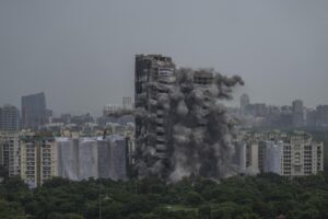 Explosives are detonated to demolish twin high-rise apartment towers in Noida, outskirts of New Delhi, India, Sunday, Aug. 28, 2022. The demolition was done after the country’s top court declared them illegal for violating building norms. The 32-story and 29-story towers, constructed by a private builder were yet to be occupied and became India’s tallest structures to be razed to the ground. (AP Photo/Altaf Qadri)