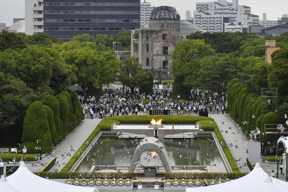 Doves fly over the cenotaph dedicated to the victims of the atomic bombing during the ceremony marking the 77th anniversary of the world’s first atomic bombing, at the Hiroshima Peace Memorial Park in Hiroshima, western Japan Saturday, Aug. 6, 2022. (Kyodo News via AP)
