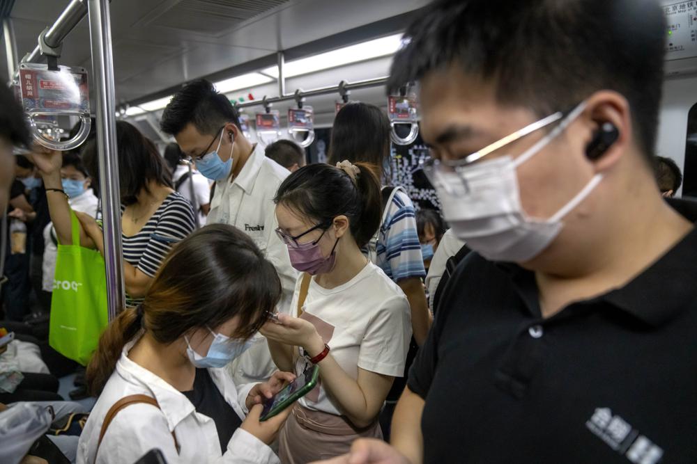 Commuters ride on a subway train during the morning rush hour in the central business district in Beijing, Tuesday, Aug. 9, 2022. China’s 11 million university graduates are struggling in a bleak job market this summer as repeated shutdowns under China’s anti-COVID lockdowns forced companies to retrench and driven many restaurants and other small employers out of business. (AP Photo/Mark Schiefelbein)