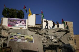 Palestinians clamber over the rubble of the house of Subhi Sbeihat after it was demolished by Israeli forces along with the house of Asad Rifai, both suspected of carrying out a deadly May 2022 attack on Israelis in the city of Elad, near Tel Aviv, in Rummana, near the West Bank city of Jenin, Monday, Aug. 8, 2022. The Israeli military says their soldiers faced a violent protest during the operation. (AP Photo/Majdi Mohammed)