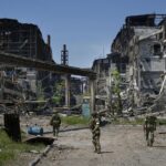 FILE – Russian soldiers patrol an area of the Metallurgical Combine Azovstal, in Mariupol, on the territory which is under the Government of the Donetsk People’s Republic control, eastern Ukraine, on June 13, 2022. Despite getting bogged down in Ukraine, the Kremlin has resisted announcing a full-blown mobilization, a move that could prove to be very unpopular for President Vladimir Putin. That has led instead to a covert recruitment effort that includes trying to get prisoners to make up for the manpower shortage. (AP Photo, File)