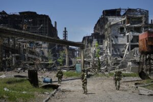 FILE – Russian soldiers patrol an area of the Metallurgical Combine Azovstal, in Mariupol, on the territory which is under the Government of the Donetsk People’s Republic control, eastern Ukraine, on June 13, 2022. Despite getting bogged down in Ukraine, the Kremlin has resisted announcing a full-blown mobilization, a move that could prove to be very unpopular for President Vladimir Putin. That has led instead to a covert recruitment effort that includes trying to get prisoners to make up for the manpower shortage. (AP Photo, File)