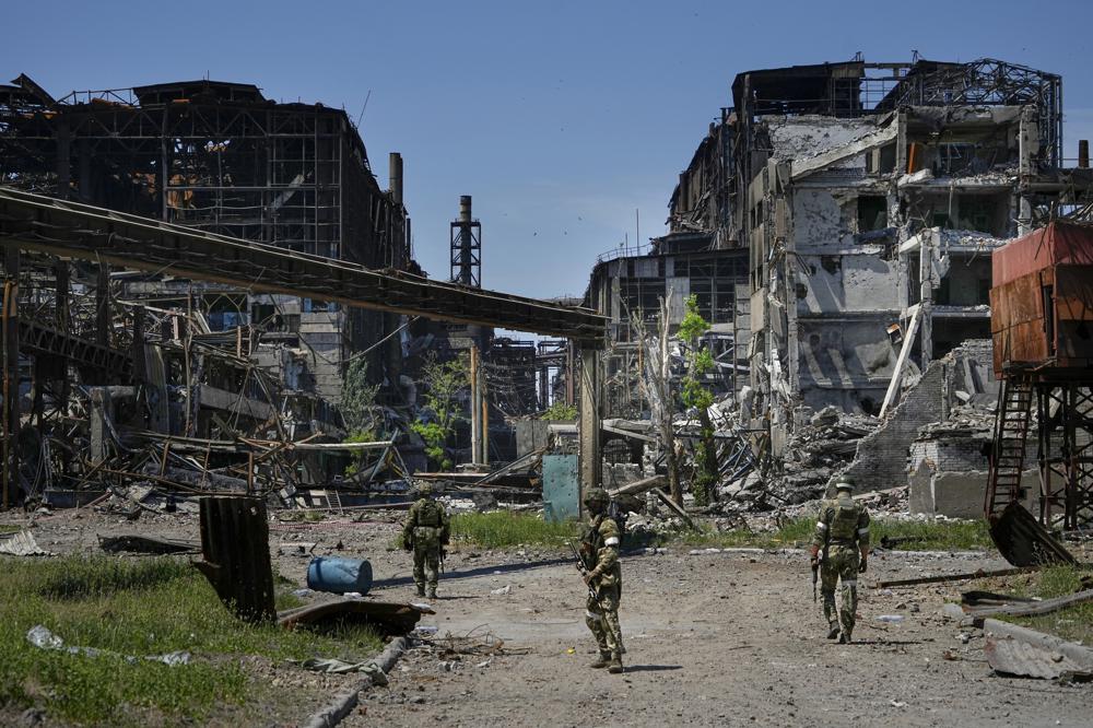 FILE – Russian soldiers patrol an area of the Metallurgical Combine Azovstal, in Mariupol, on the territory which is under the Government of the Donetsk People’s Republic control, eastern Ukraine, on June 13, 2022. Despite getting bogged down in Ukraine, the Kremlin has resisted announcing a full-blown mobilization, a move that could prove to be very unpopular for President Vladimir Putin. That has led instead to a covert recruitment effort that includes trying to get prisoners to make up for the manpower shortage. (AP Photo, File)