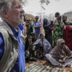 World Food Program chief David Beasley, left, meets with villagers in the village of Wagalla in northern Kenya Friday, Aug. 19, 2022. The United States is stepping up to buy about 150,000 metric tons of grain from Ukraine in the next few weeks for an upcoming shipment of food aid from ports no longer blockaded by war, the World Food Program chief has told The Associated Press. (AP Photo/Brian Inganga)