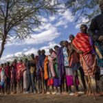 Maasai wait in line to cast their votes in the general election at a polling station in Esonorua Primary School, in Kajiado County, Kenya Tuesday, Aug. 9, 2022. Polls opened Tuesday in Kenya’s unusual presidential election, where a longtime opposition leader who is backed by the outgoing president faces the deputy president who styles himself as the outsider. (AP Photo/Ben Curtis)