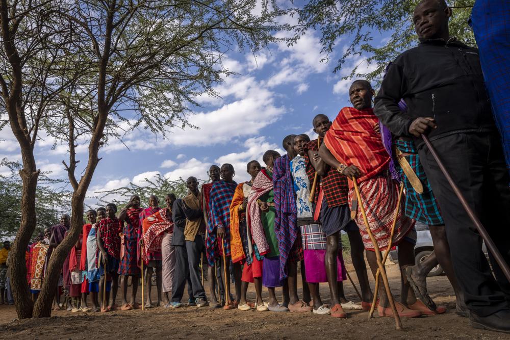 Maasai wait in line to cast their votes in the general election at a polling station in Esonorua Primary School, in Kajiado County, Kenya Tuesday, Aug. 9, 2022. Polls opened Tuesday in Kenya’s unusual presidential election, where a longtime opposition leader who is backed by the outgoing president faces the deputy president who styles himself as the outsider. (AP Photo/Ben Curtis)