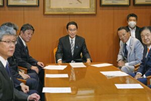 Japanese Prime Minister Fumio Kishida poses for a photo before a meeting with his party members including Toshimitsu Motegi, second left, and Taro Aso, second right, at the party’s headquarters in Tokyo, Wednesday, Aug. 10, 2022. Kishida is set to reshuffle his Cabinet on Wednesday in a move seen as trying to distance his administration from controversial ties to the Unification Church following former leader Shinzo Abe’s assassination. (Yohei Fukai/Kyodo News via AP)