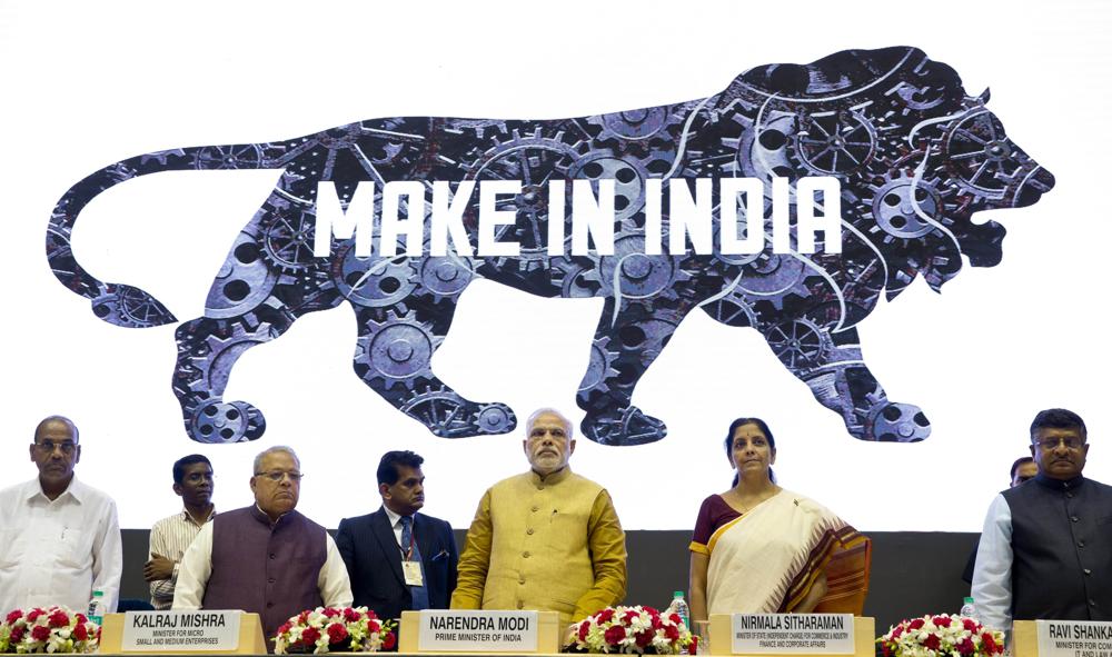 FILE – Indian Prime Minister Narendra Modi, center, unveils the logo of ‘Make in India’ initiative in New Delhi, India, Sept. 25, 2014. India’s phenomenal transformation from an impoverished nation in 1947 into an emerging global power whose $3 trillion economy is Asia’s third largest has made it a major exporter of things like software and vaccines. The country marks 75 years of independence from British rule on Aug. 15. (AP Photo/Saurabh Das, File)