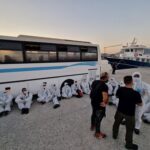 This photo provided by the Hellenic Coast Guard shows migrants at a port on the southeastern Aegean Sea island of Kos, Greece, after a rescue operation on Wednesday, Aug. 10, 2022. Greek authorities conducted a major search and rescue operation Wednesday for dozens of people believed missing at sea east of the island of Karpathos after a boat reportedly carrying up to 80 migrants towards Italy sank during the night. The coast guard said 29 men were rescued 33 nautical miles (38 miles, 61 kilometers) off Karpathos, a southeastern island between Rhodes and Crete. (Hellenic Coast Guard via AP)