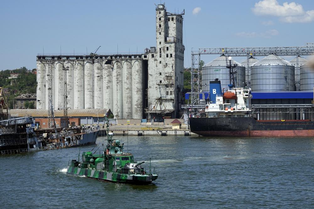 FILE – A Russian military boat guards an area with the grain storage in the background at the Mariupol Sea Port which has recently started its work after heavy fighting in Mariupol, on the territory which is under the Government of the Donetsk People’s Republic control, eastern Ukraine, June 12, 2022. Ukraine is steadily exporting grains from its Black Sea ports under a wartime deal brokered last month, but the agreement has also proven helpful to Russian farmers and the country’s cornerstone agriculture industry. This photo was taken during a trip organized by the Russian Ministry of Defense. (AP Photo, File)