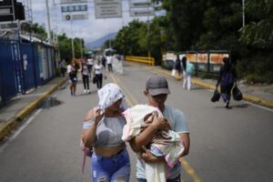 A Venezuelan couple use the Francisco De Paula Santander Bridge to cross between Urena, Venezuela and Cucuta, Colombia, Saturday, Aug. 6, 2022. The border will gradually reopen after the two nations restore diplomatic ties when Colombia’s new president is sworn-in on Aug. 7, according to announcement in late July by Colombia’s incoming Foreign Minister Alvaro Leyva and Venezuelan Foreign Minister Carlos Faria. (AP Photo/Matias Delacroix)