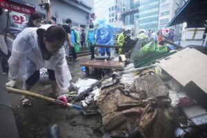 A woman cleans up debris after the water drained from a submerged traditional market following heavy rainfall in Seoul, South Korea, Tuesday, Aug. 9, 2022. Heavy rains drenched South Korea’s capital region, turning the streets of Seoul’s affluent Gangnam district into a river, leaving submerged vehicles and overwhelming public transport systems. (AP Photo/Ahn Young-joon)