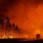 This photo provided by the fire brigade of the Gironde region SDIS 33, (Departmental fire and rescue service 33) shows firefighters tackling a blaze near Saint-Magne, south of Bordeaux, southwestern France, Wednesday, Aug. 10, 2022. (SDIS 33 via AP)