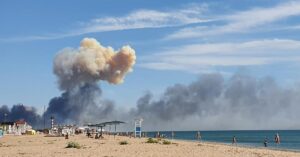 Rising smoke can be seen from the beach at Saky after explosions were heard from the direction of a Russian military airbase near Novofedorivka, Crimea, Tuesday Aug. 9, 2022. The explosion of munitions caused a fire at a military air base in Russian-annexed Crimea Tuesday but no casualties or damage to stationed warplanes, Russia’s Defense Ministry said. (UGC via AP)