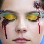A woman made up with wounds and with Ukrainian colors attends a so called Freedom March demonstration, marking the Ukrainian Independence Day in Berlin, Germany, Wednesday, Aug. 24, 2022. European leaders are pledging unwavering support for Ukraine as the war-torn country marks its Independence Day. The commemorations Wednesday coincide with the six-month milestone of Russia’s invasion. (AP Photo/Markus Schreiber)