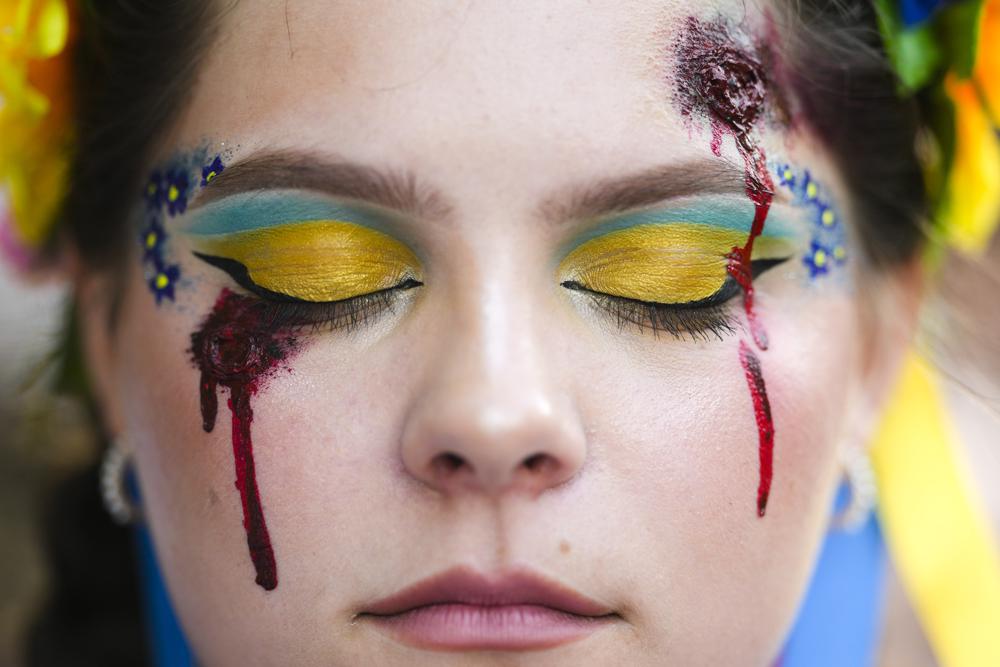 A woman made up with wounds and with Ukrainian colors attends a so called Freedom March demonstration, marking the Ukrainian Independence Day in Berlin, Germany, Wednesday, Aug. 24, 2022. European leaders are pledging unwavering support for Ukraine as the war-torn country marks its Independence Day. The commemorations Wednesday coincide with the six-month milestone of Russia’s invasion. (AP Photo/Markus Schreiber)
